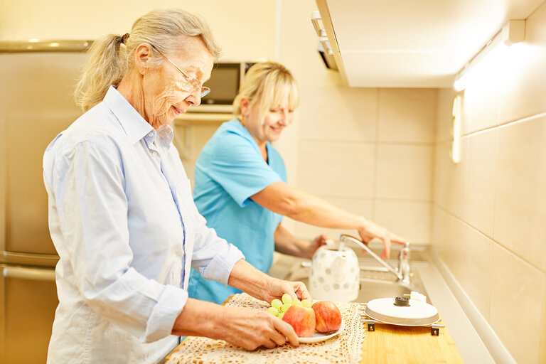 Pflegedienstleiterin und Seniorin gemeinsam in der Küche im betreuten Wohnen