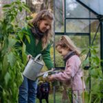 Mutter und Kind beim Gießen im Garten
