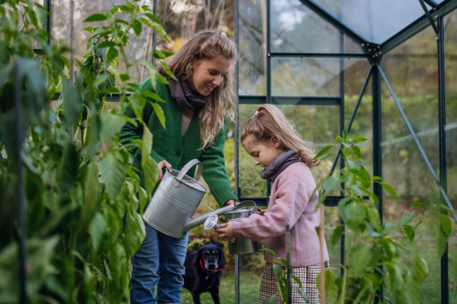 Mutter und Kind beim Gießen im Garten